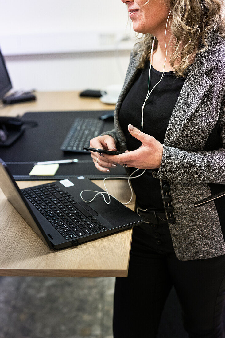 Businesswoman using laptop and smart phone