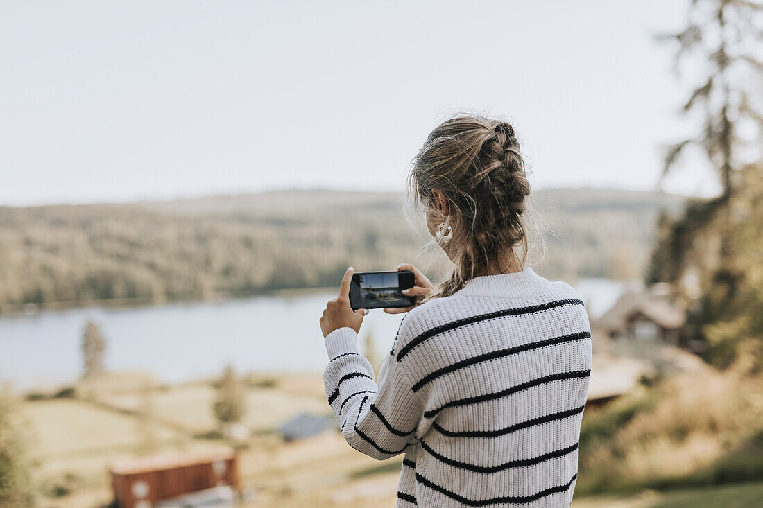 Young woman taking photo with cell phone