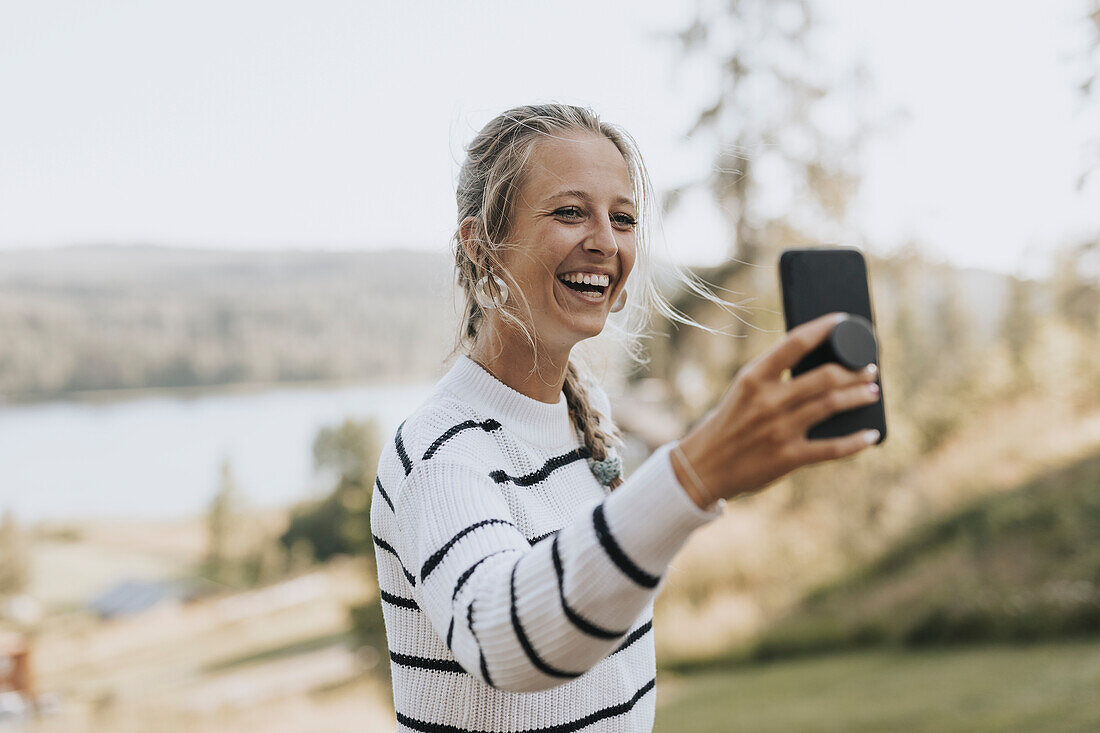 Junge Frau beim Fotografieren mit dem Handy