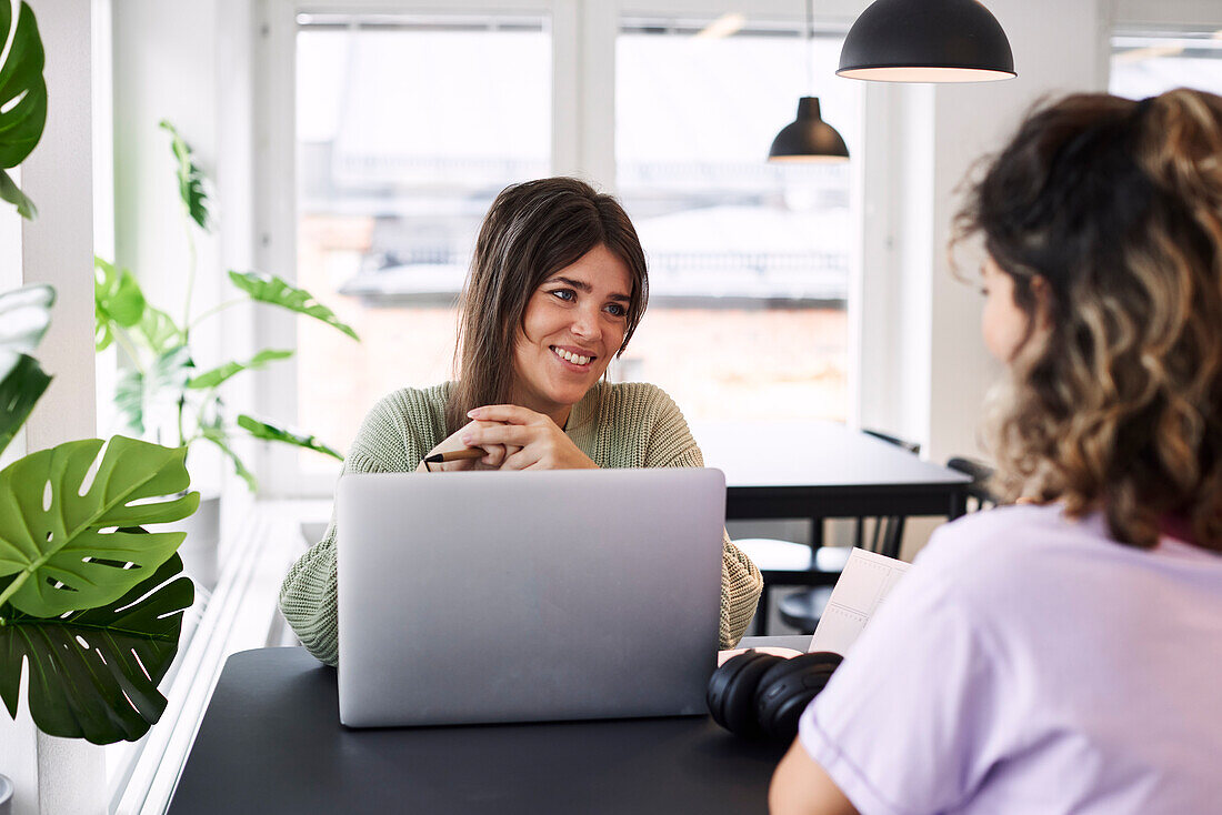 Smiling woman using laptop