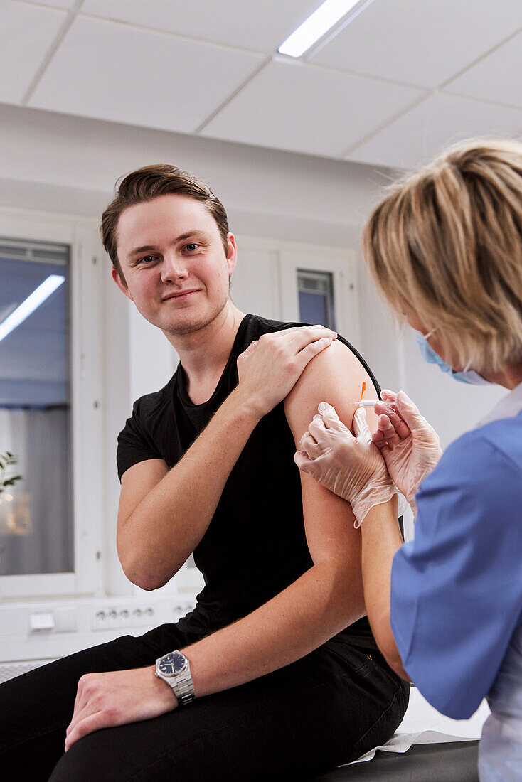 Portrait of young man getting vaccinated against Covid-19