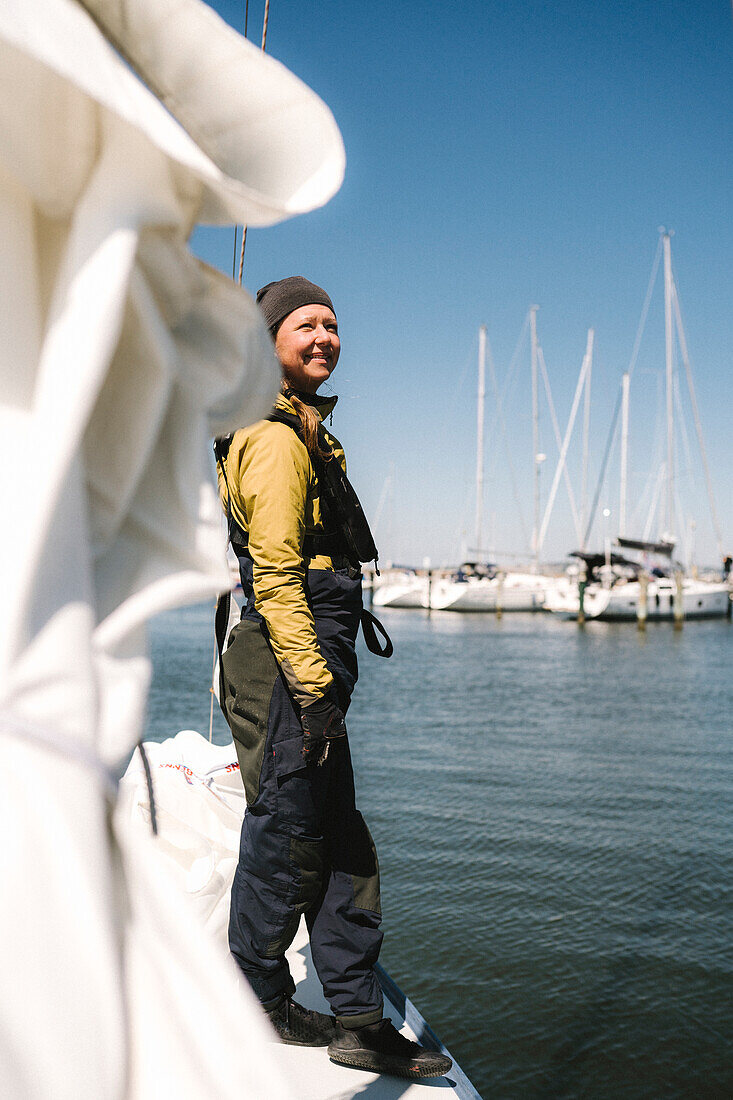 Lächelnde Frau auf Boot im Yachthafen