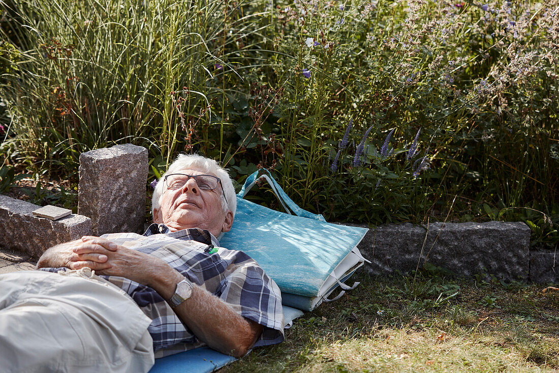 Senior man relaxing on lawn