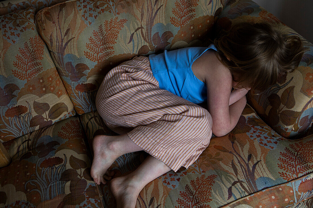 Barefoot girl lying on sofa