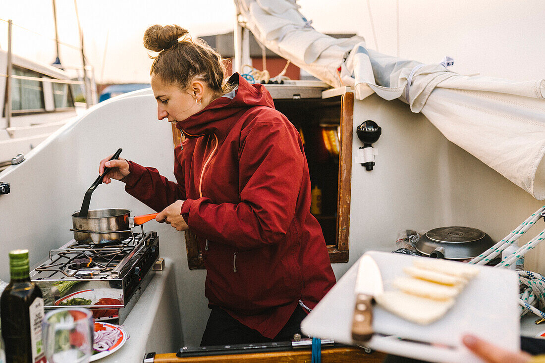 Frau kocht Mahlzeit auf einem Boot