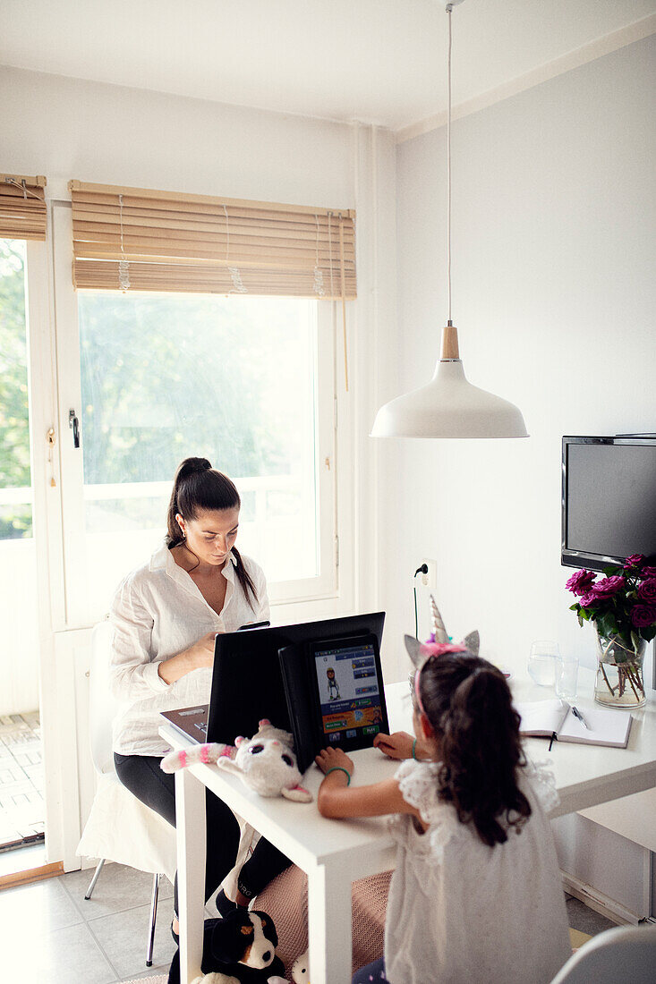 Mother and daughter sitting at table