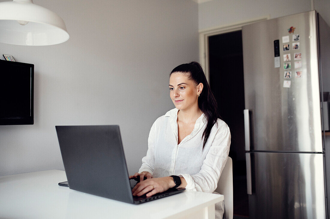 Woman at table using laptop