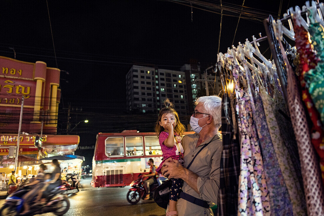 Großvater hält Enkelin auf der Straße bei Nacht