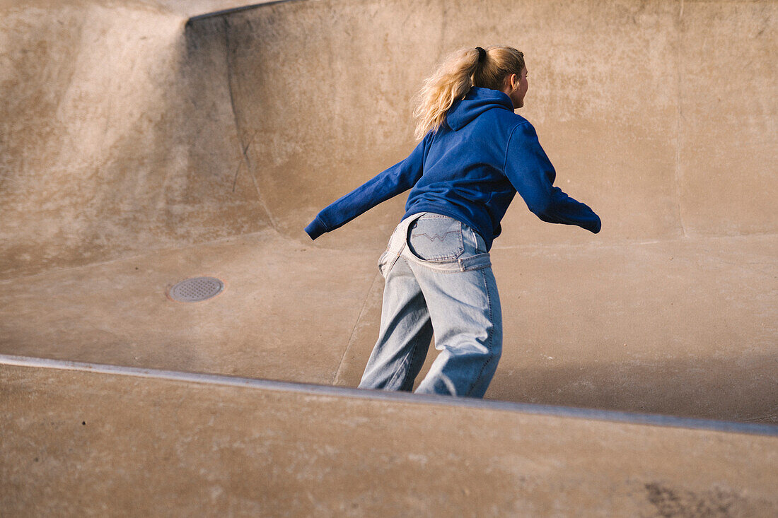 Teenager-Mädchen fährt Skateboard im Skatepark