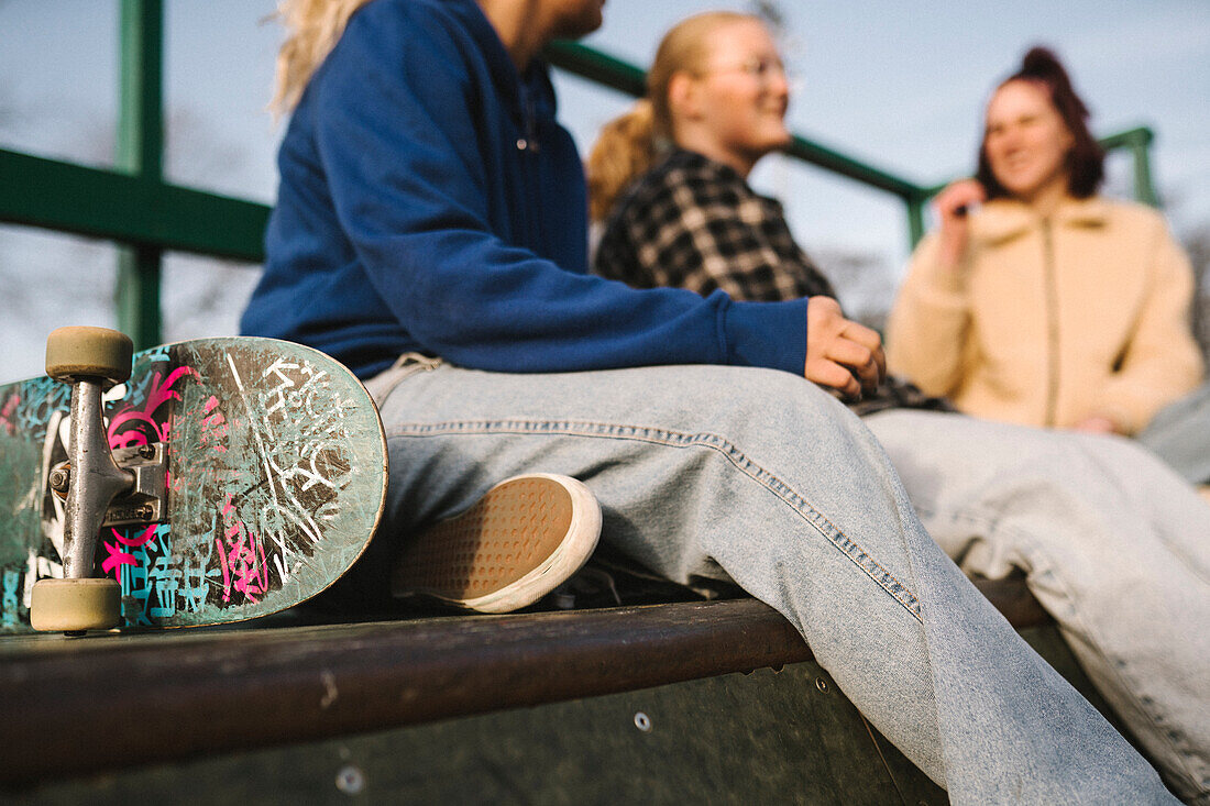 Teenager-Mädchen mit Skateboard im Skatepark sitzend