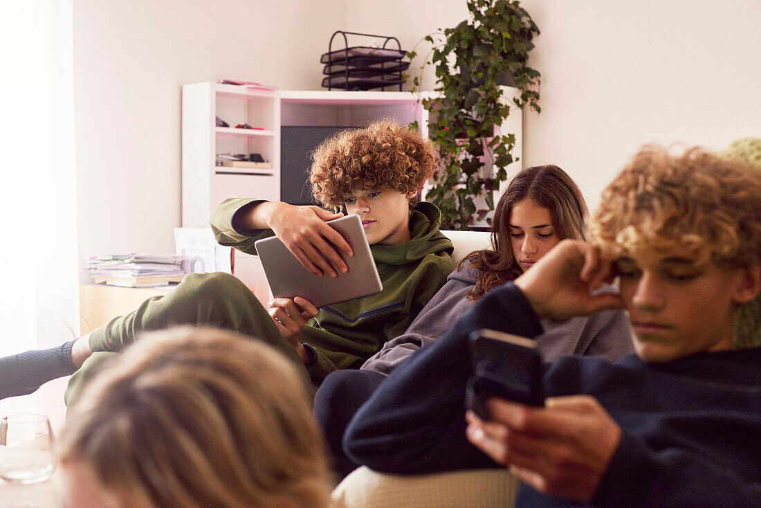 Siblings using electronic devices at home