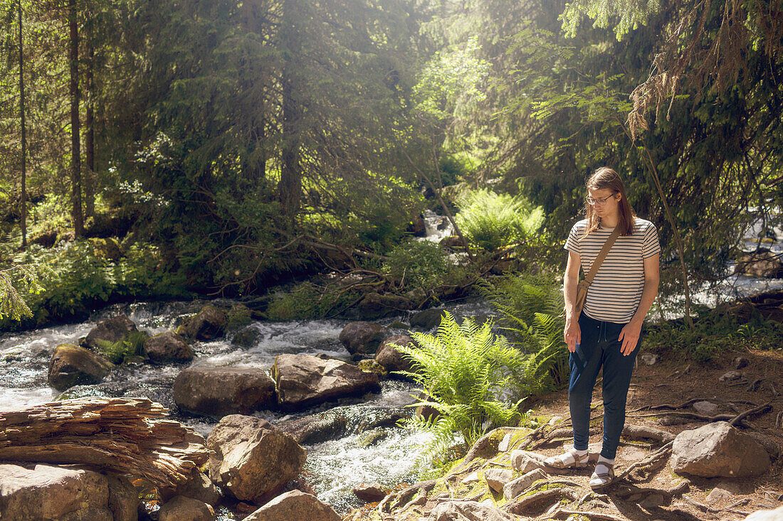 Junger Mann am Waldfluss