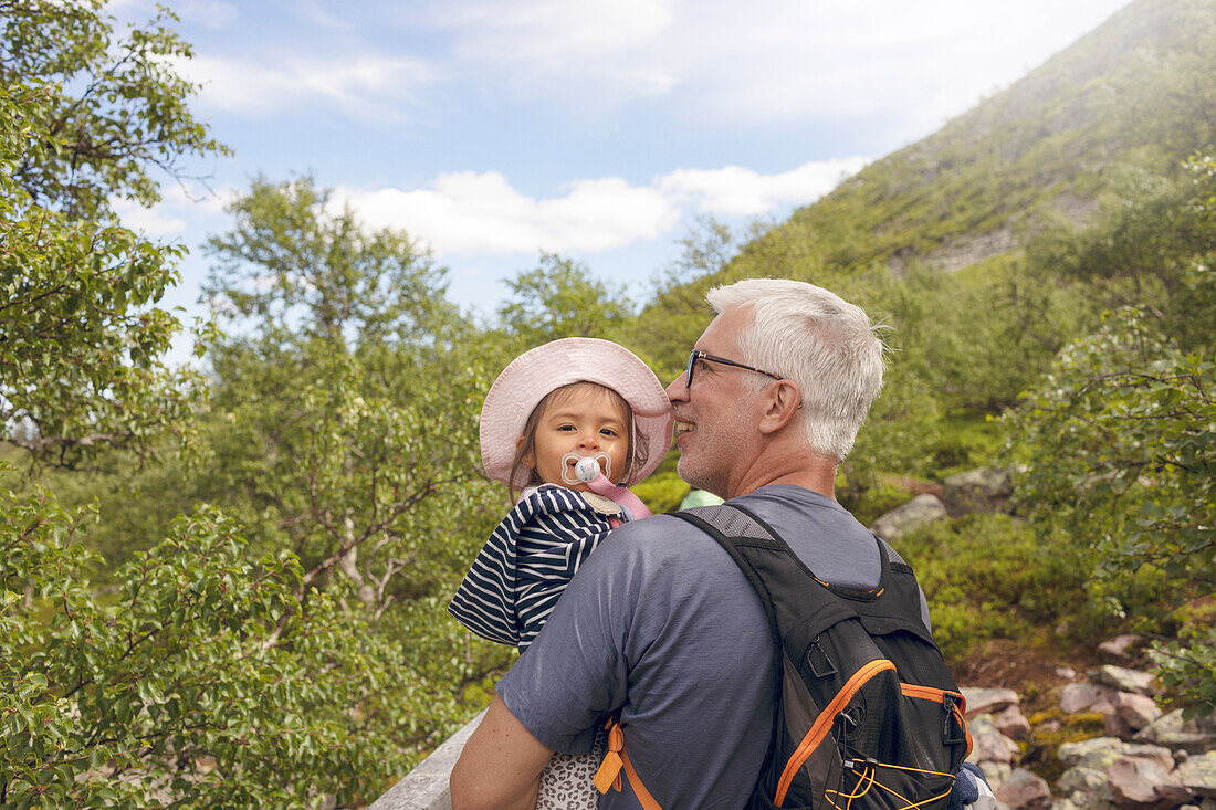 Father carrying toddler girl