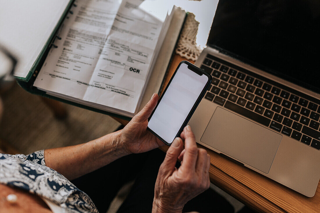 Senior woman paying bills on smart phone