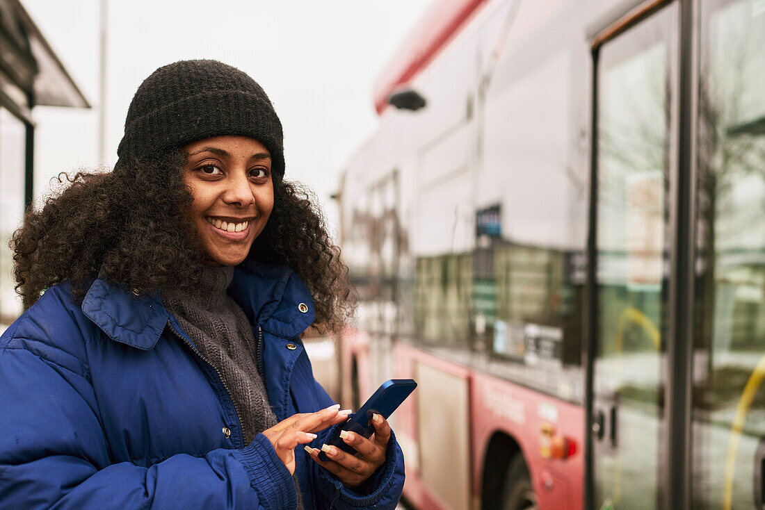 Woman using phone at bus stop