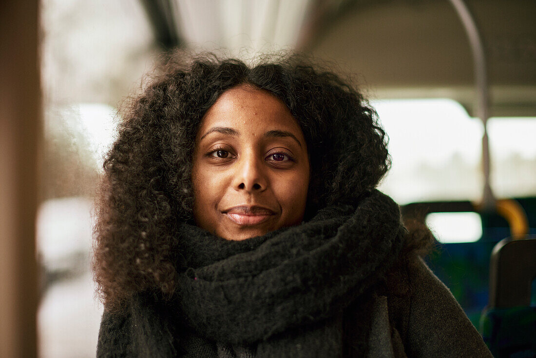 Frau im Bus schaut in die Kamera