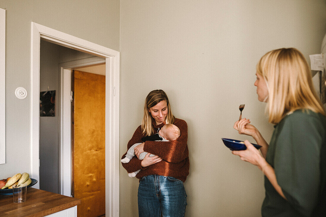 Mütter mit neugeborenem Baby beim Essen zu Hause