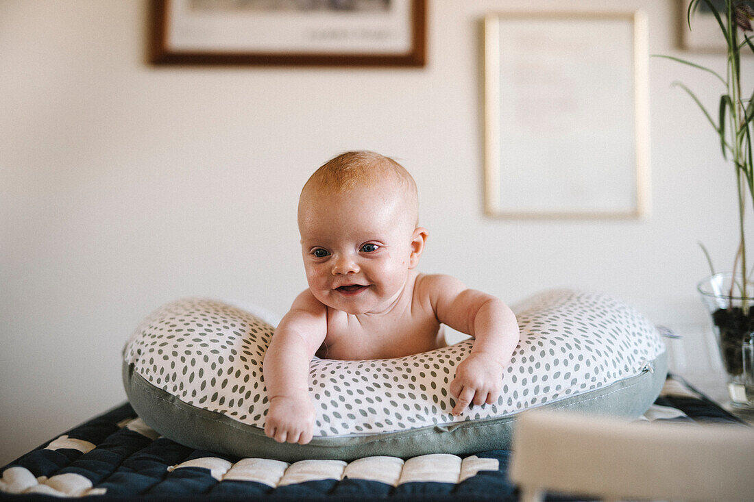 Lächelndes neugeborenes Baby auf dem Kopfkissen