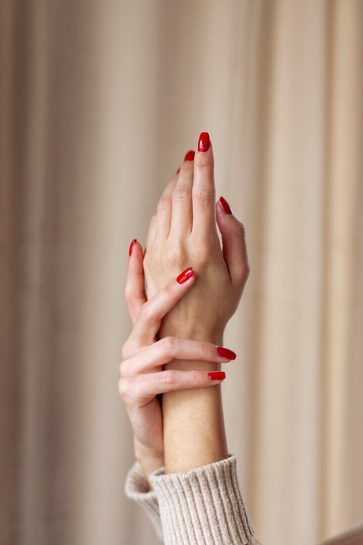 Close-up of female hands with red nail polish