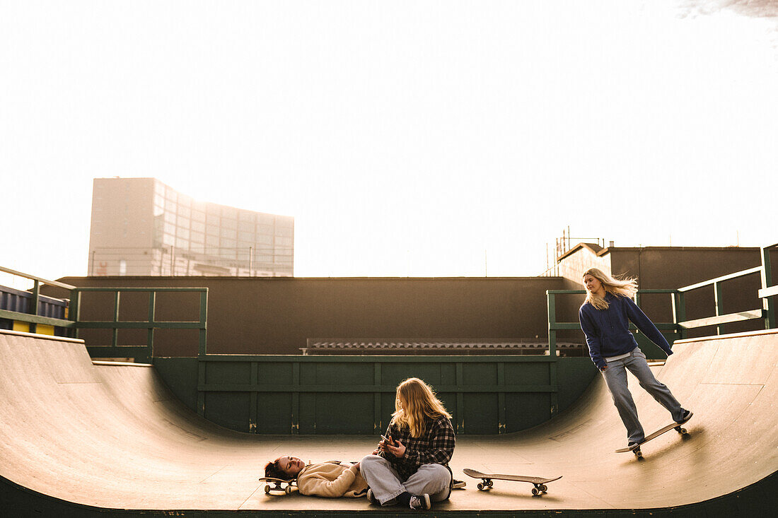 Teenage girls skateboarding in skatepark