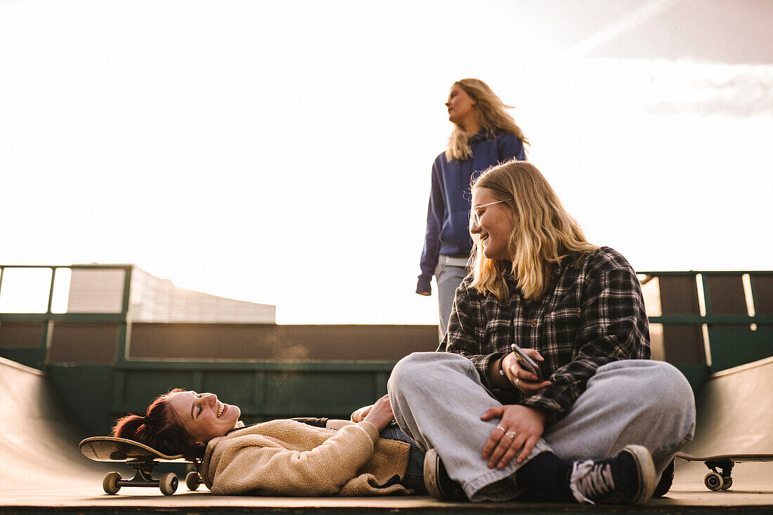 Teenager-Mädchen mit Skateboards entspannen sich im Skatepark