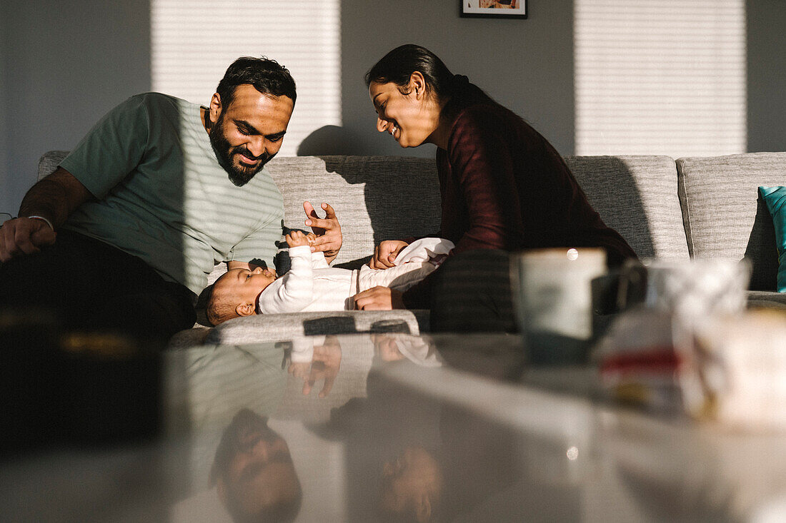 Father and mother with baby on sofa