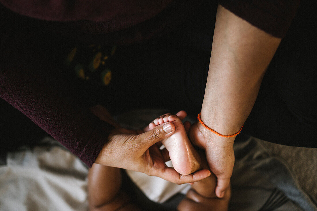 Mutter massiert Fuß des Babys