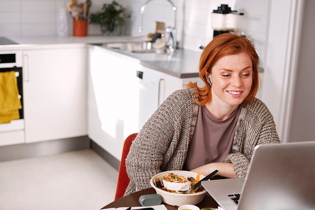 Smiling woman using laptop