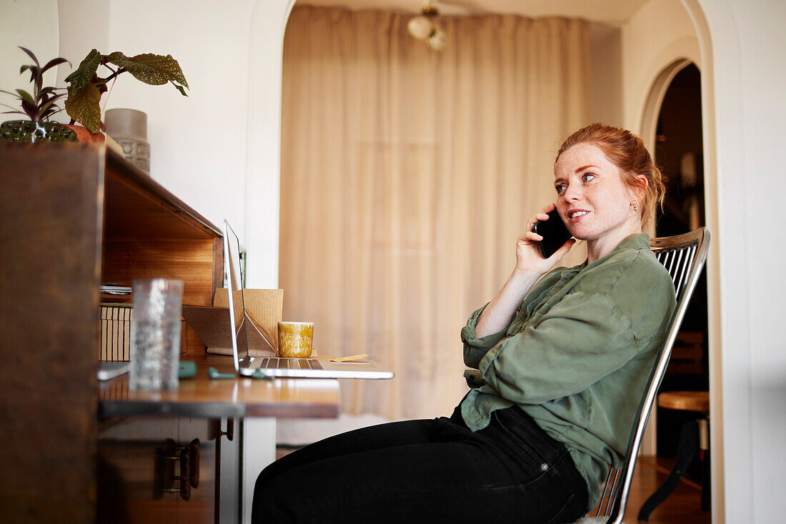 Woman at home talking via cell phone