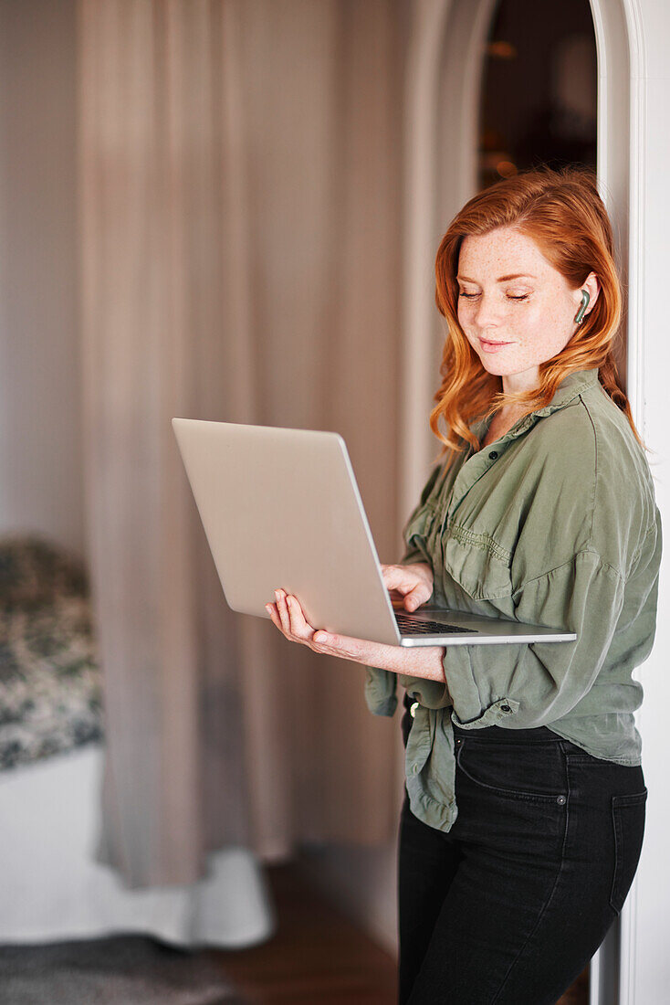 Lächelnde Frau mit Laptop in der Hand