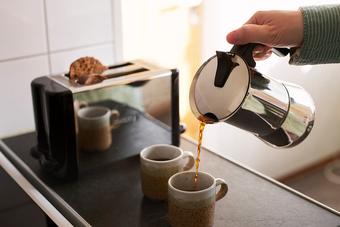 Woman pouring coffee into cup