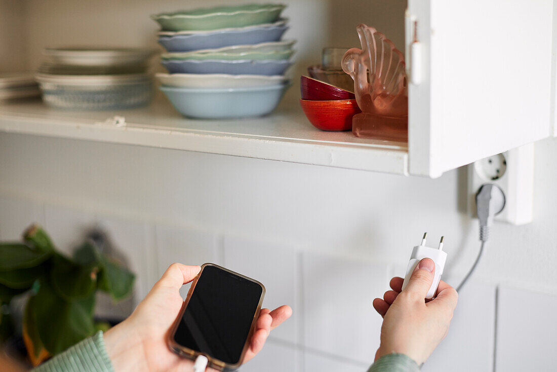 Hand plugging in or out an electric cord into socket