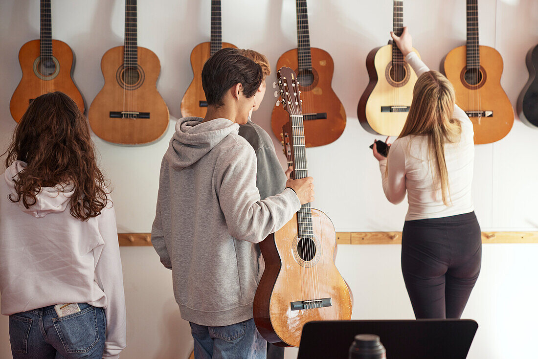 Teenager beim Gitarrenunterricht