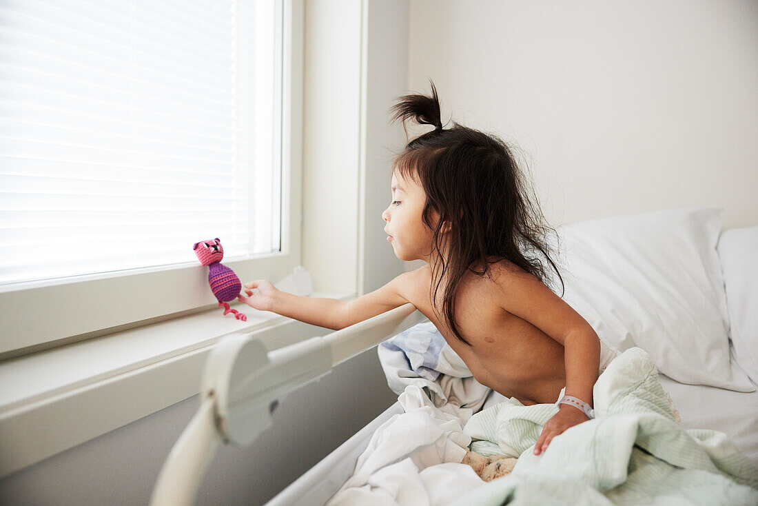 Girl playing in hospital bed