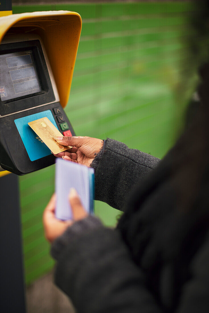 Frau bezahlt Fahrkarte mit Kreditkarte