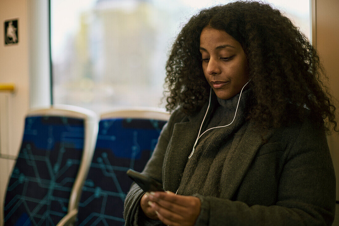Frau im Zug benutzt Mobiltelefon