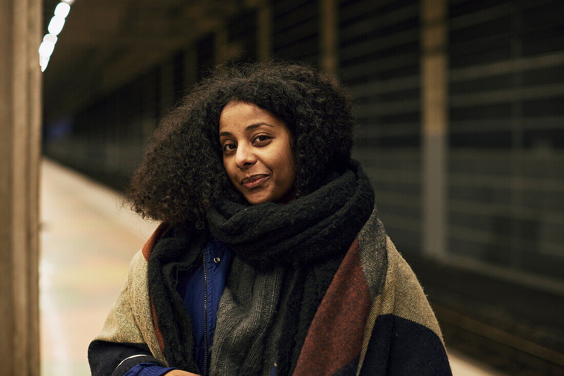 Lächelnde Frau am Bahnhof stehend