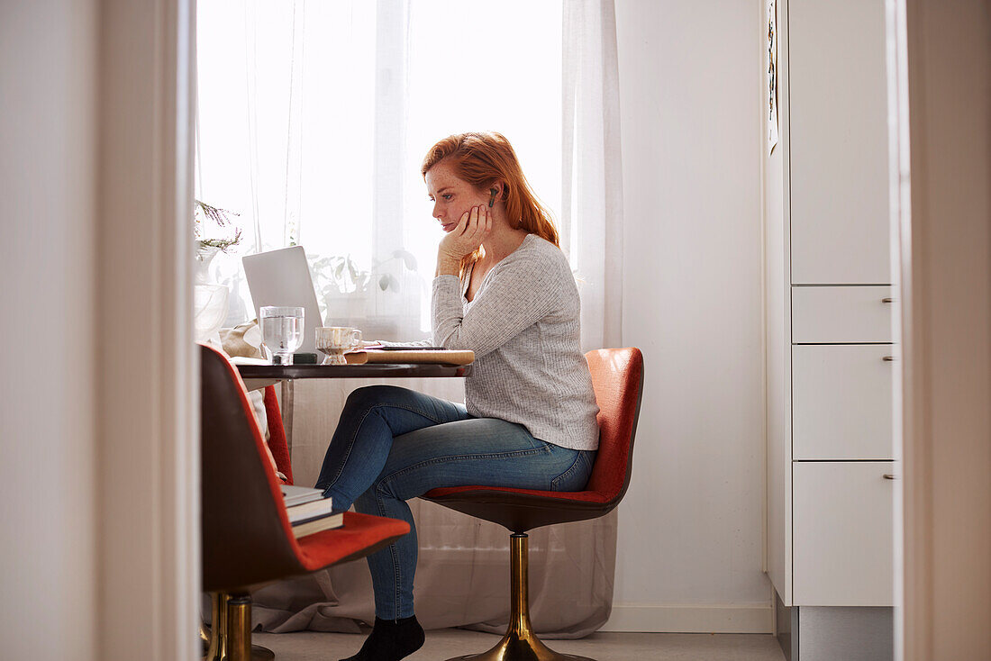 Woman at home using laptop