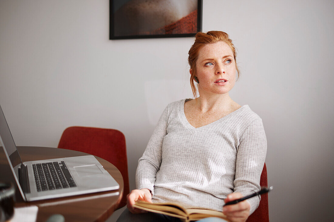 Woman in front of laptop looking away