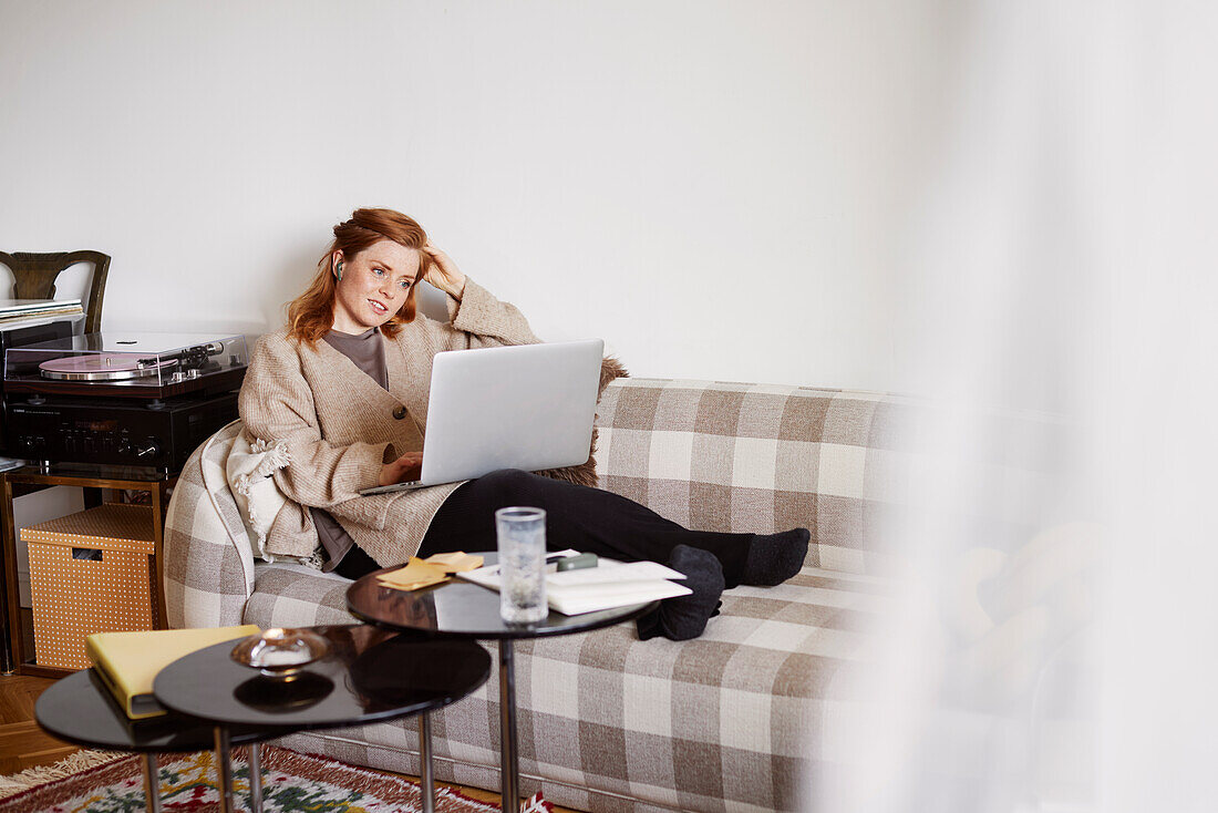 Woman on sofa using laptop