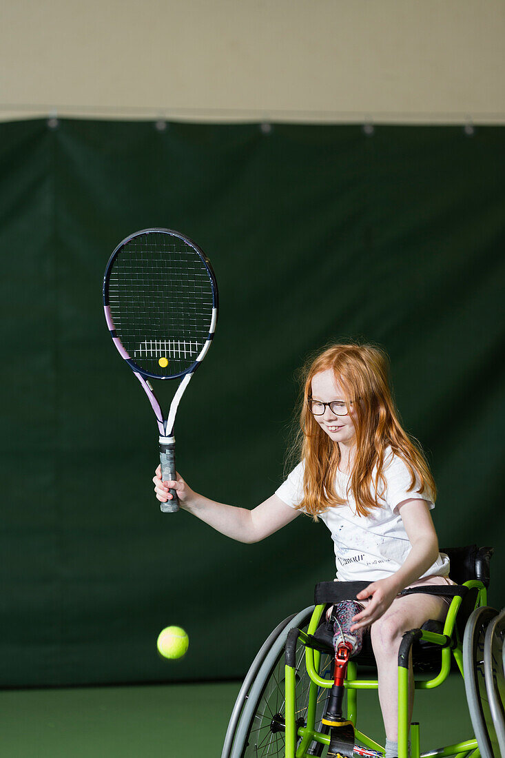 Girl in wheelchair playing tennis