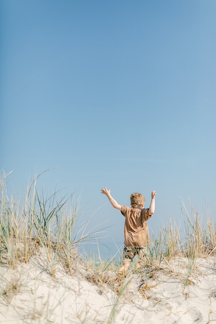 Junge rennt auf Sanddüne