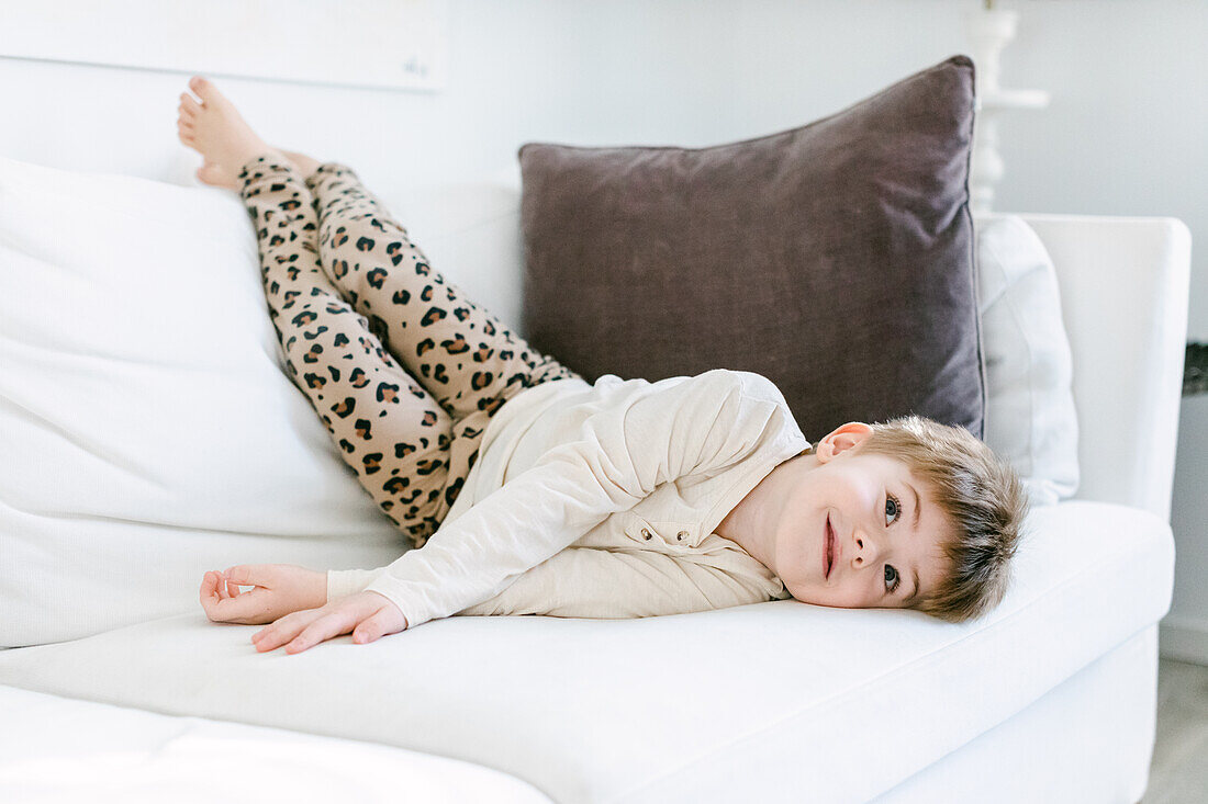 Smiling boy lying on sofa