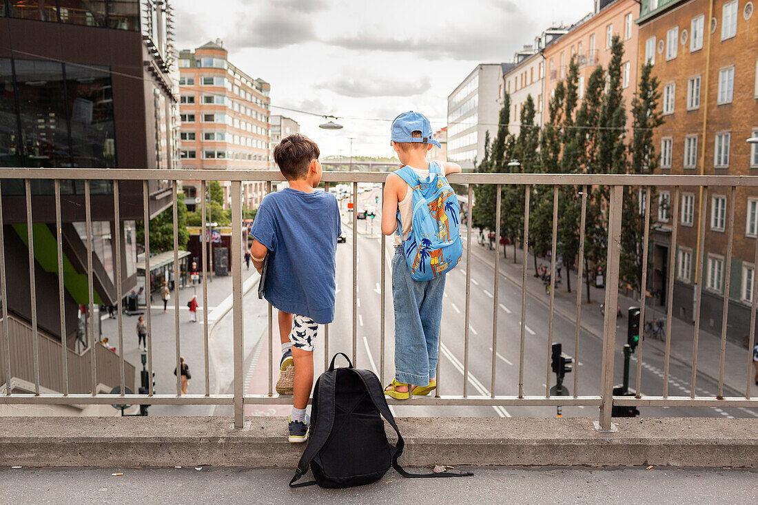 Kinder, die auf einem Viadukt stehen und auf die Straße schauen