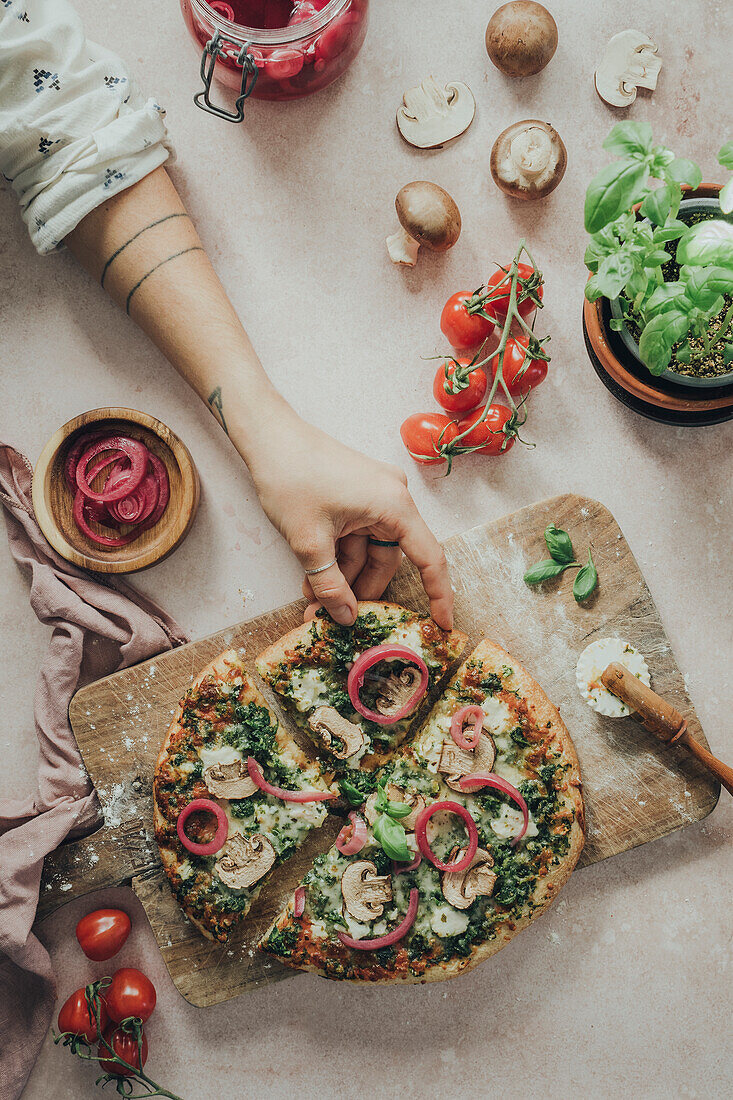 Hands reaching for homemade pizza