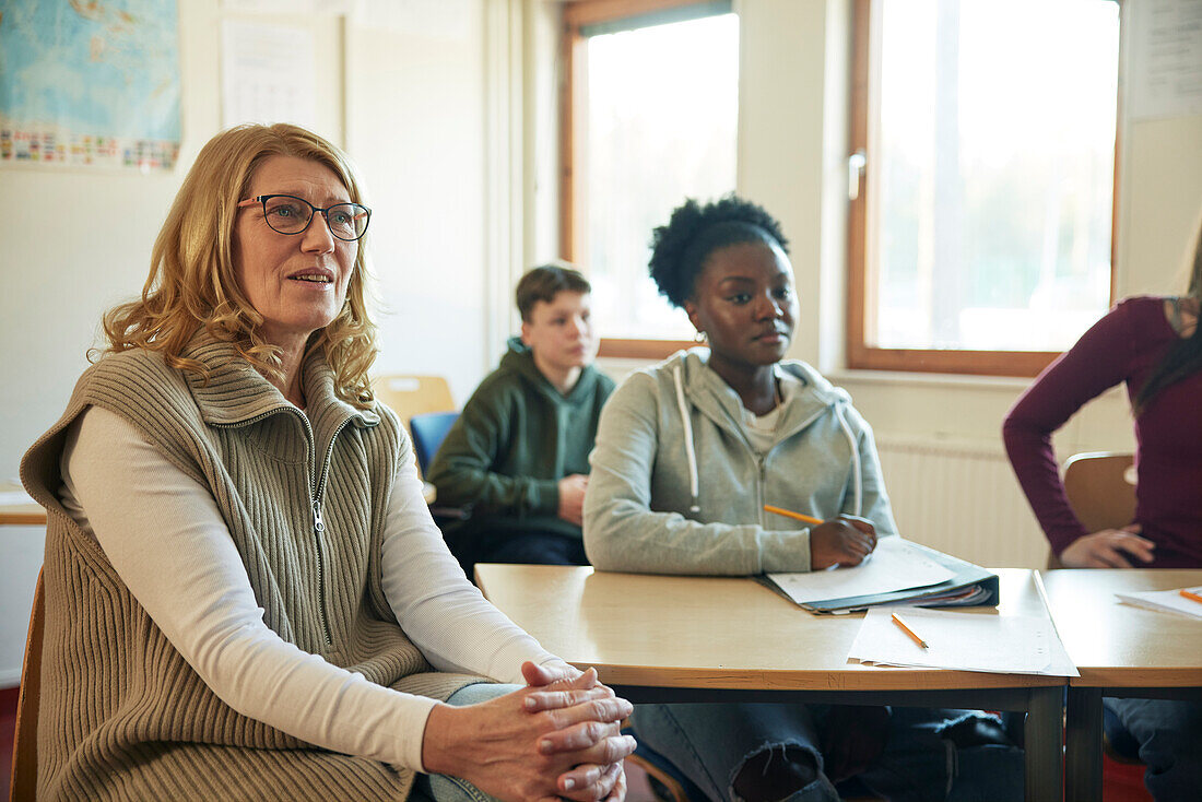 Gruppe von Schülern und Lehrern, die in der Klasse sitzen