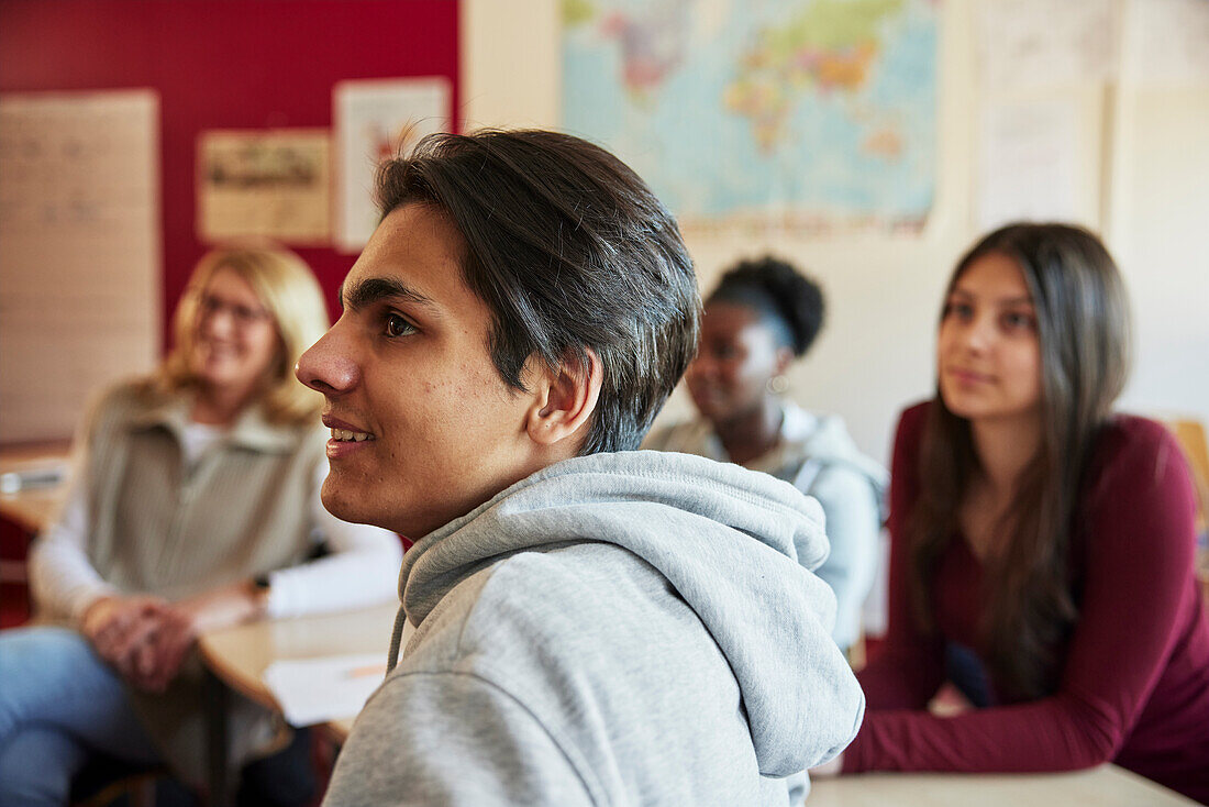 Gruppe von Schülern und Lehrern, die in der Klasse sitzen