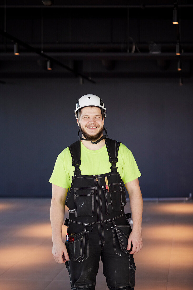 Lächelnder Arbeiter schaut in die Kamera