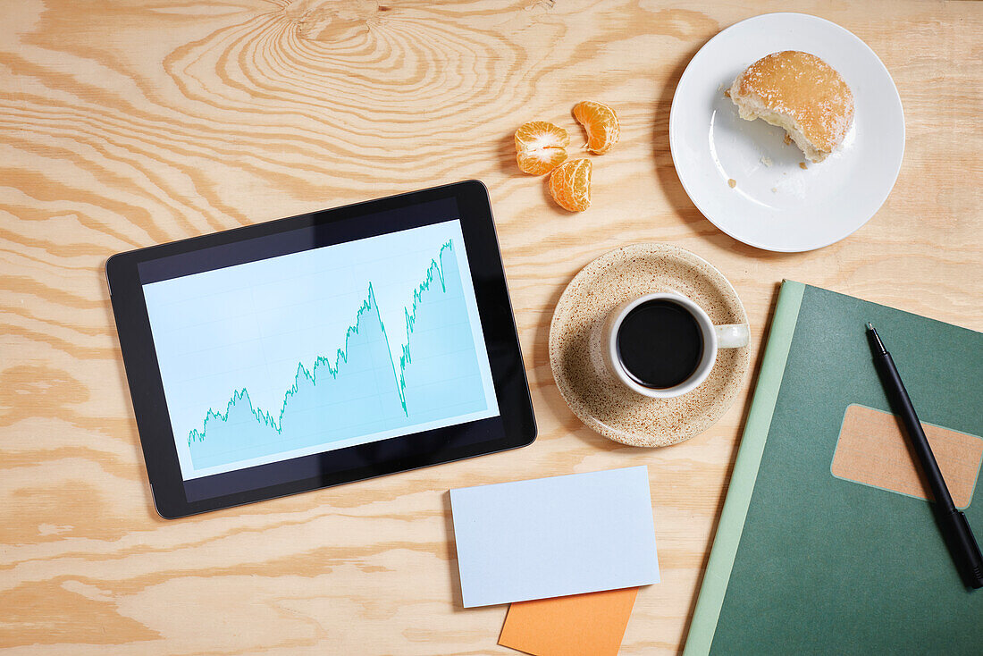 Blick auf den Schreibtisch mit Tablet und Kaffeetasse