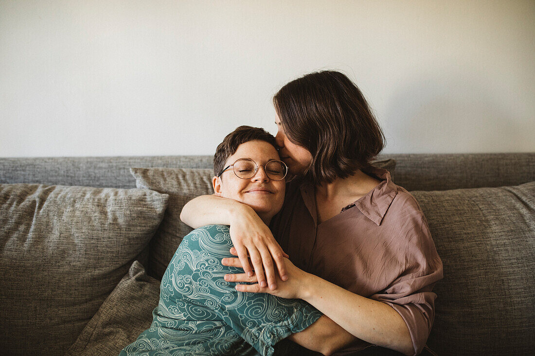 Happy female couple sitting on sofa